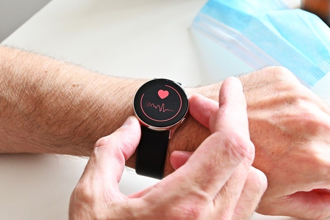Person måler sin puls med et smartwatch, der viser et hjerte og en kurve