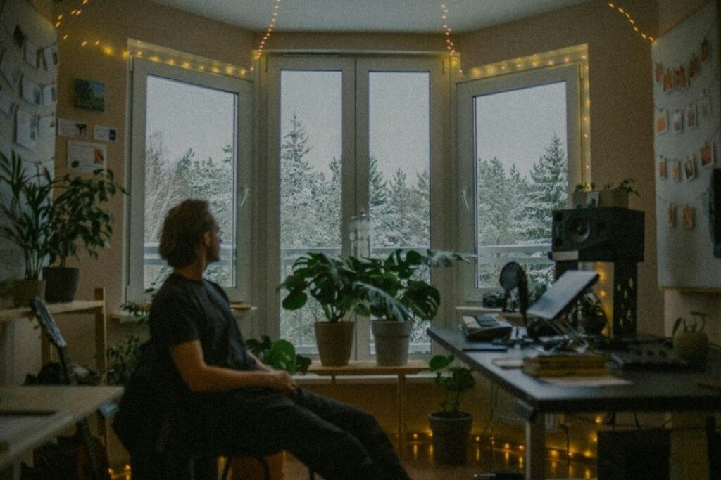 Person tager en stille pause og ser ud ad vinduet i et hjemmekontor